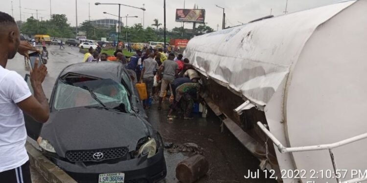 Tanker Falls At Costain, Crushes Car And Spills Its Content On The Road (Video)