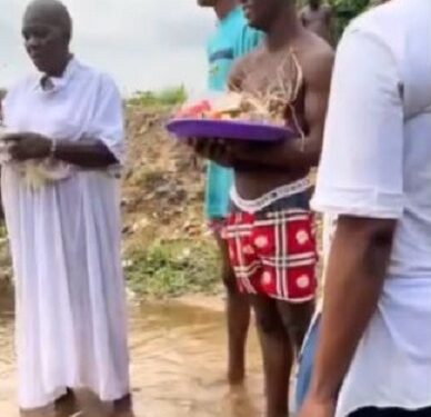 Nigerian Man Who Threw Money In The Air While People Picked Is Spotted Carrying Out A ‘Ritual’ With A Native Doctor In A River (Video)