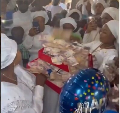 Benin Big Girls Storm Church With Money Cakes And Boxes Filled With Money To Surprise Their ‘Spiritual Mother’ (Video)