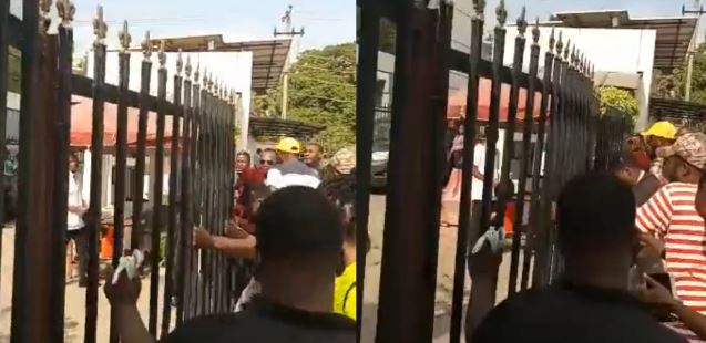 Naira Scarcity: The Moment Some Angry Abuja Residents Forcefully Unlocked Gate Of A Bank (Video)