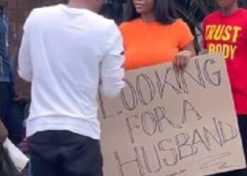 Beautiful Lady Carries Placard On Road With Inscription “Looking For A Husband” (Video)