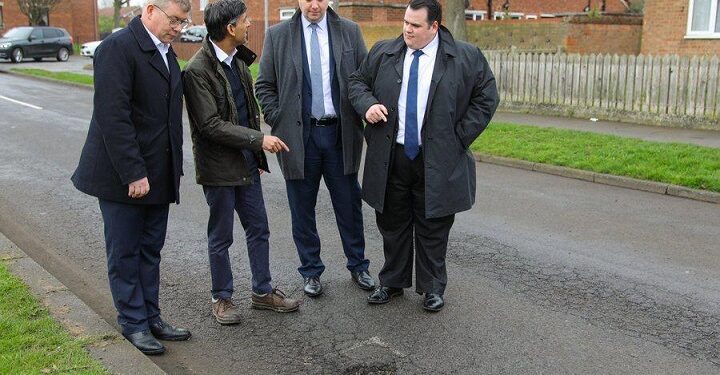 “See The Way Pothole Fine” – Nigerians React To Trending Photo Of UK Prime Minister And His Cabinet Members Posing In Front Of A Pothole Troubling Their Country (Comments)