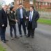 “See The Way Pothole Fine” – Nigerians React To Trending Photo Of UK Prime Minister And His Cabinet Members Posing In Front Of A Pothole Troubling Their Country (Comments)